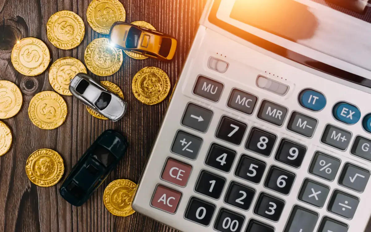 Calculator beside gold coins and toy cars — working out the best time to sell a junk car
