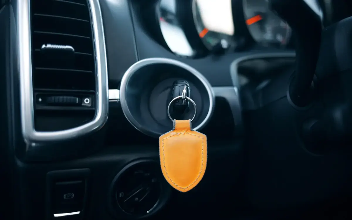 Car key with an orange leather fob in the ignition — selling a car without the keys